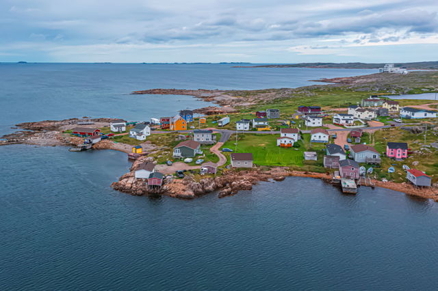 Barr'd Island where vibrant houses meet the rugged embrace of the North Atlantic, painting tales of resilience and unity on Fogo Island's canvas