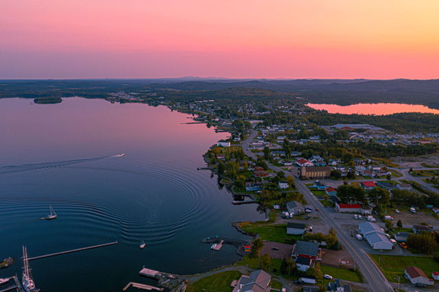 Golden hues paint the sky as the sun sets over Lewisporte, NL, casting a warm glow on the tranquil waters